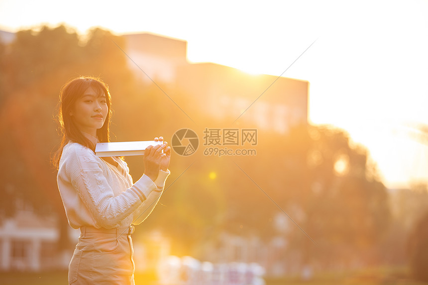 夕阳下活泼的女大学生图片