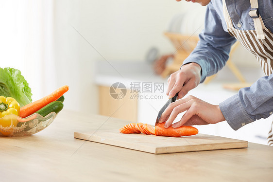 年轻男士在厨房切菜特写图片