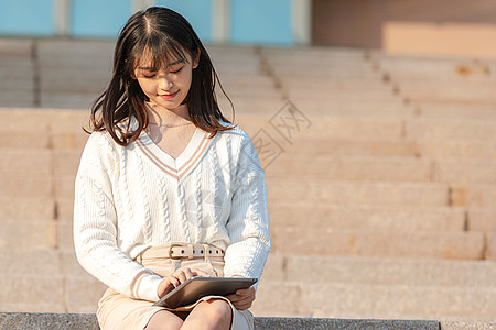 窗台看书少女甜美女大学生户外玩平板电脑背景