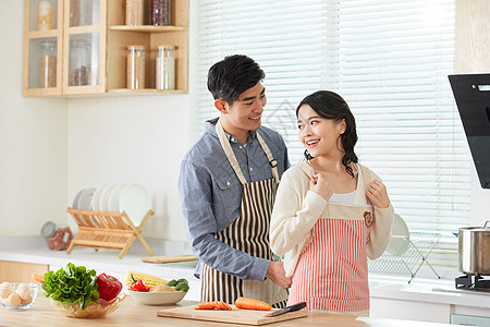 年轻男士给妻子系戴围裙图片