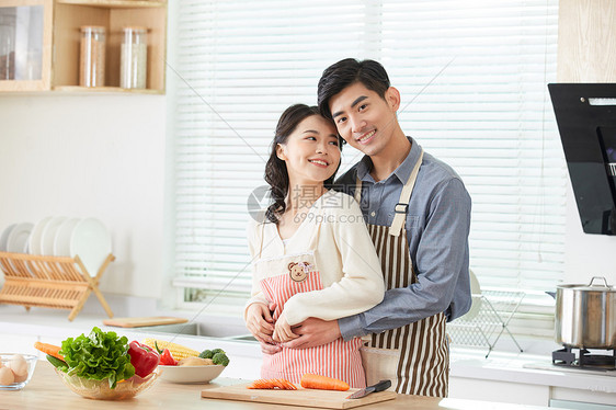 年轻夫妻在厨房一起做菜图片