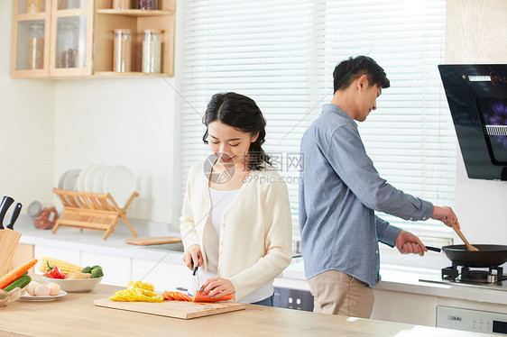 年轻夫妻在厨房一起做菜图片