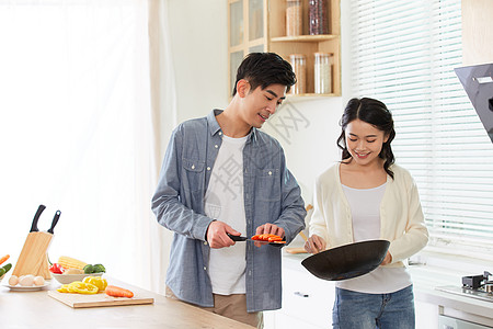 年轻夫妻在厨房一起做菜图片