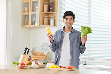 年轻男士在厨房拿蔬菜展示图片
