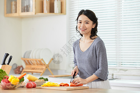 年轻女士在厨房切菜图片