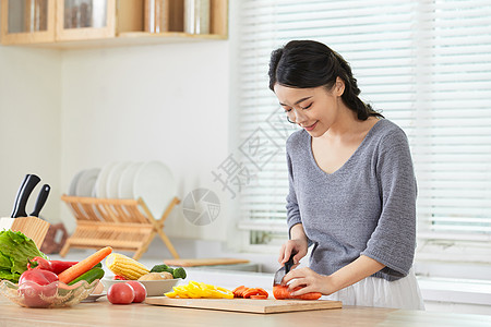 年轻女士在厨房切菜图片