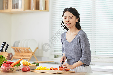 年轻女士在厨房切菜图片