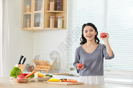 年轻女士在厨房备菜图片
