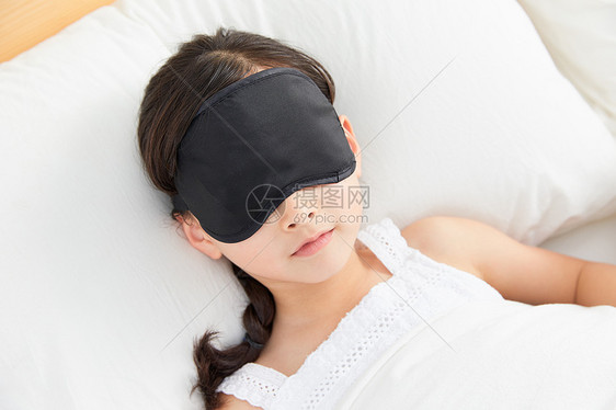小女孩躺在床上戴眼罩睡午觉图片