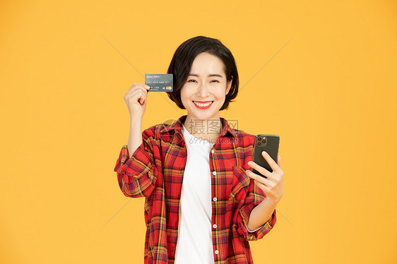 青年女性刷信用卡手机网购图片