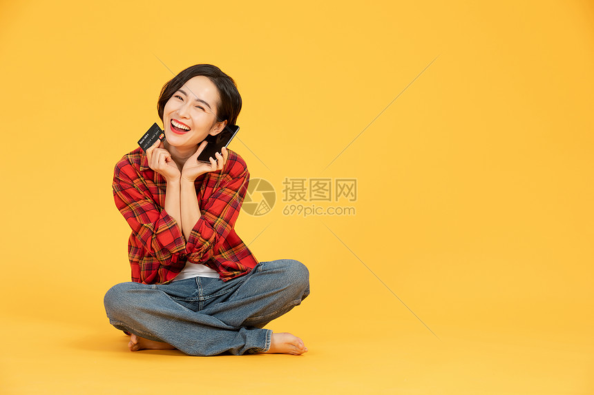 青年女性刷信用卡手机网购图片