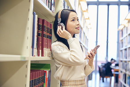 女学生在图书馆听音乐高清图片