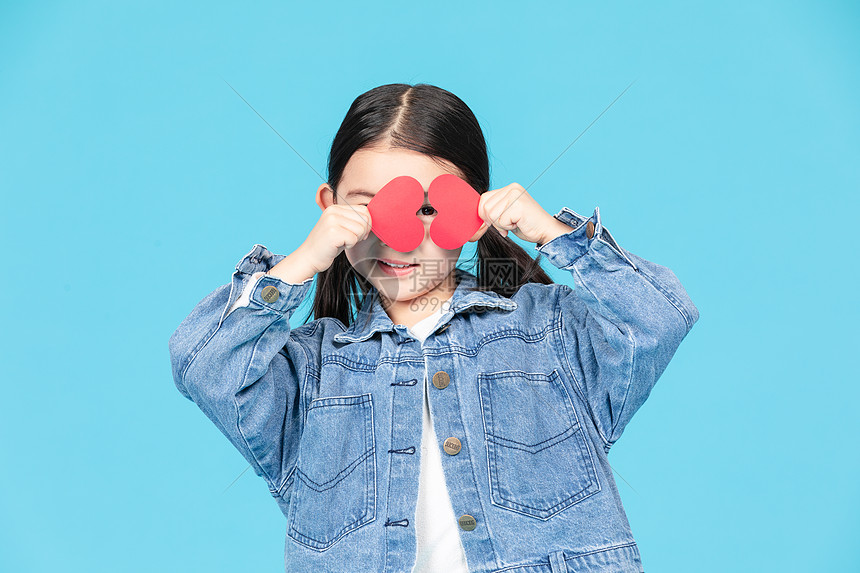 小女孩拿爱心小卡片搞怪拍照图片