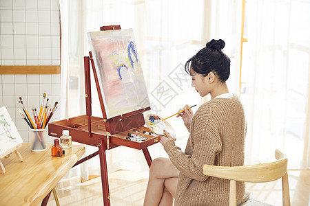 年轻美女在家绘画调色图片