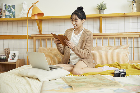 年轻美女在家制定旅行计划背景图片