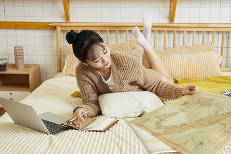 年轻美女在家制定旅行计划高清图片