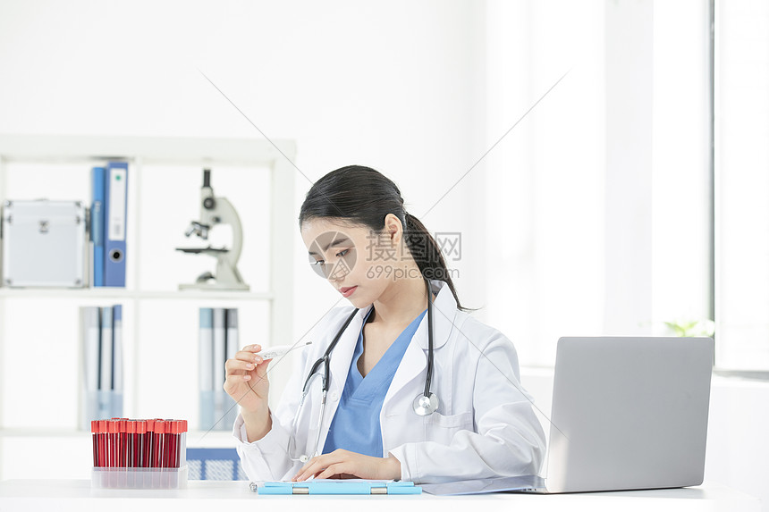 女性医生拿着电子体温计观察图片