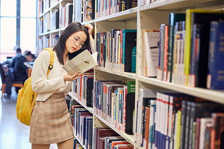 科技教育年轻女学生在图书馆看书背景