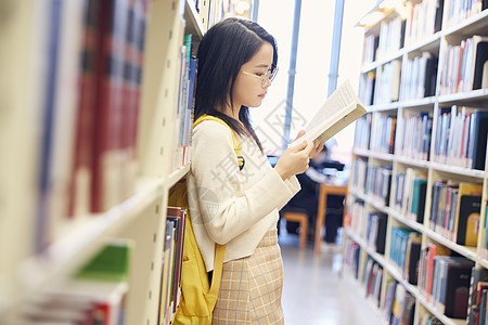 年轻女学生在图书馆看书图片