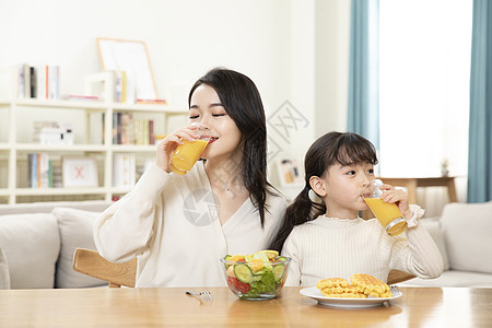 喝果汁的人母女居家生活喝橙汁背景