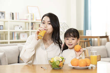 喝果汁的人母女居家生活喝橙汁背景