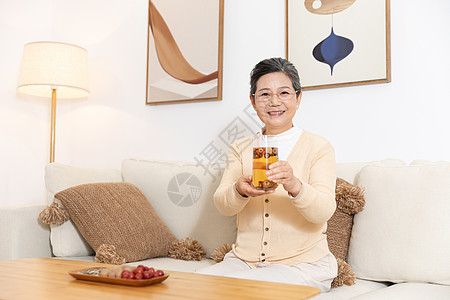 老奶奶坐沙发上手捧养生茶图片
