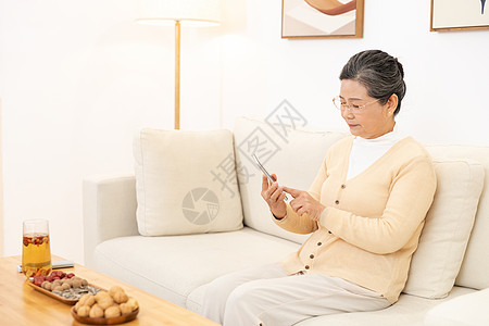 老奶奶坐沙发上玩手机高清图片