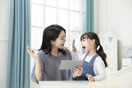 在线课堂妈妈指导女儿用平板电脑在家上课背景