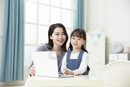 远程教育妈妈陪着女儿用笔记本电脑上网课背景