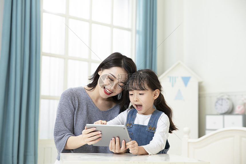 妈妈陪伴女儿平板电脑在家上课图片