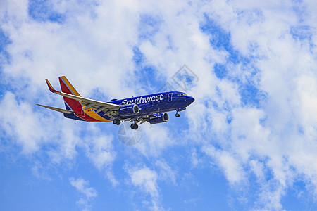 美国航班大型客机飞翔在蓝天白云背景图片