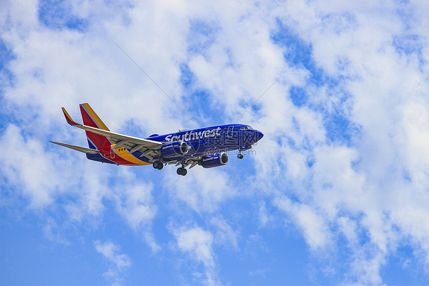 美国航班大型客机飞翔在蓝天白云图片