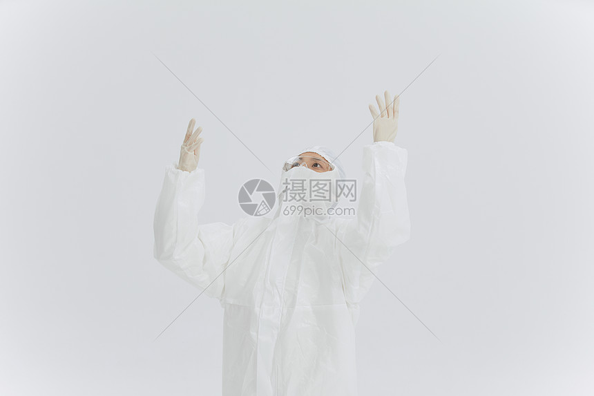 穿防护服的医护人员注视上方图片