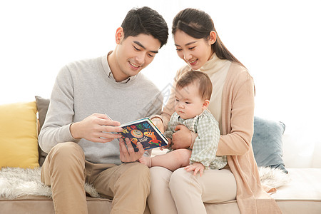 可爱宝宝爸爸妈妈给婴儿看书讲故事背景
