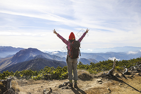 拥抱大自然在山顶张开双臂的女人背影背景