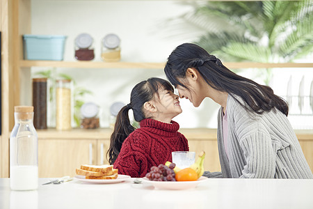 家庭餐厅年轻妈妈和女儿吃早餐互动背景