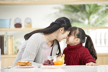 年轻妈妈和女儿吃早餐互动高清图片