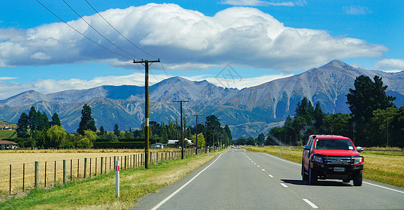 高山公路新西兰自驾风光山路红色汽车背景