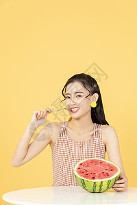 用勺子吃西瓜的甜美女性图片