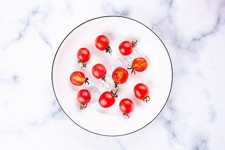 俯拍白色餐具里的红色小柿子图片