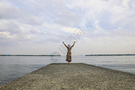 站在日本热海海边张开双臂伸向天空的女人背影图片