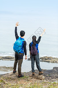 野外海边背包男女挥手高清图片