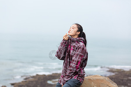 坐在海边拉链的女生图片