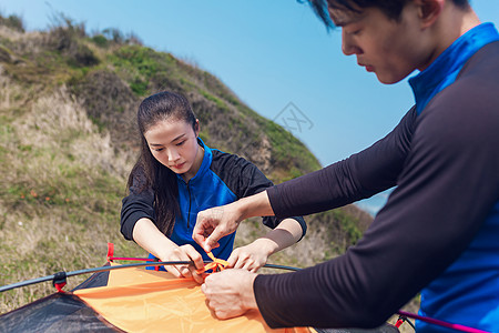 海边情侣野外绑帐篷绳背景