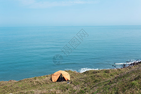 海边山坡上的黄色帐篷图片