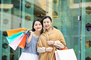 母女拎购物袋逛街购物图片