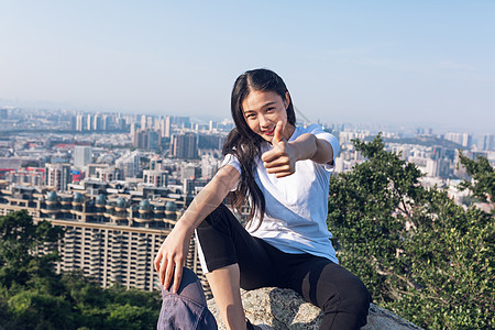 坐山顶户外坐石头上点赞美女人像背景