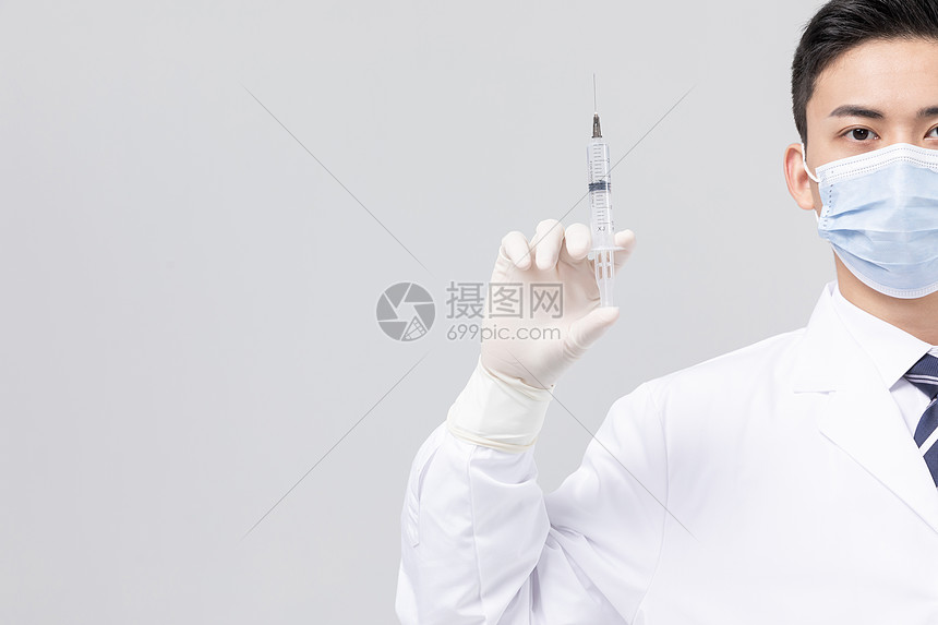 手拿针筒佩戴口罩的医生