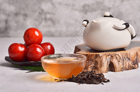 午后休闲四月的红李子配一杯清澈的红茶背景