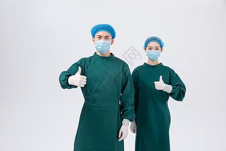手术中的医生穿手术服点赞的双人医生团队形象背景